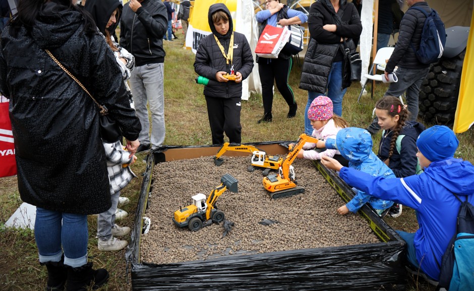 Dzieci bawiące się zdalnie sterowanymi koparkami na mini placu budowy podczas Targów Łobez eRobocze show